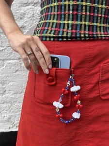 Detail of colorful beaded phone strap with red heart and white cloud charms
