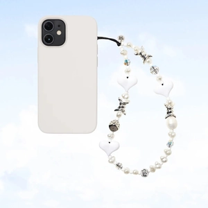 Close-up of beaded phone strap with white pearls and metal heart charms on blue background