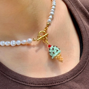 Détail du collier de perles avec fermoir à bascule doré et pendentif crème glacée
