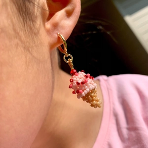 Gros plan sur des boucles d'oreilles artisanales en perles en forme de cornet de glace