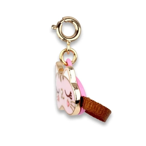 Close-up of pink enamel cat charm with golden metal ring and brown ribbon detail