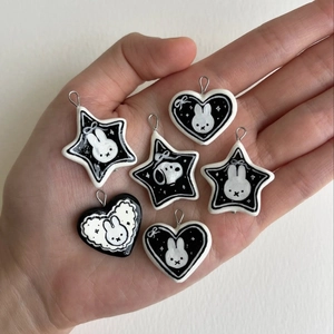 Macro view of handmade black and white heart and star pendants with cartoon designs