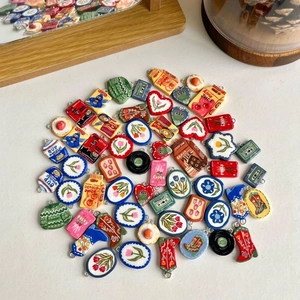 Macro shot of colorful DIY heart and snack charms with metal rings for jewelry making