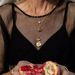 Detaillierte goldene Mehrfachkette mit Granatapfel-Anhänger und Münze am Model
