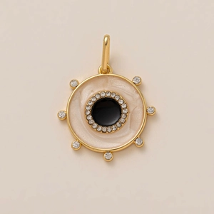 Detailed view of sun-inspired gold pendant with black enamel center and zircon stones