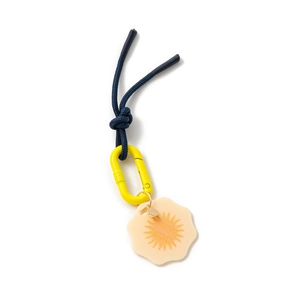 Detail of navy blue braided cord with yellow carabiner and floral petal pendant charm