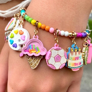 Macro shot of colorful beaded bracelet with happy charms like cake, rainbow and ice cream