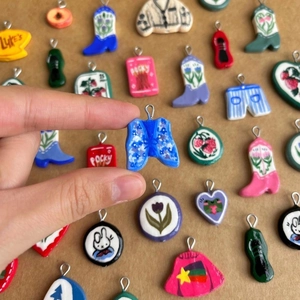 Handmade clay charms featuring colorful painted boots and cartoon shapes with metal rings