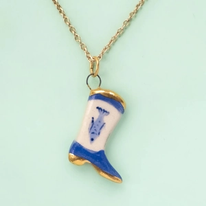 Detailed view of hand-painted ceramic rain boot pendant with gold-plated metal edges
