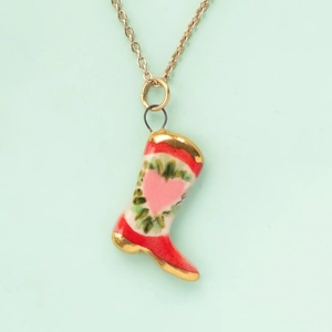 Detailed view of mermaid painted boot pendant with heart wreath on a gold chain