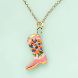 Close-up of a floral mermaid boot pendant with gold-plated chain and colorful patterns