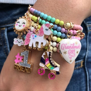 Detail of colorful beaded bracelets with smiley sun, unicorn and rainbow skate charms