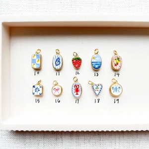 Détails macro des pendentifs en émail colorés avec motifs fraise et cœur
