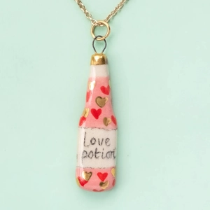Detail of Love Potion heart bottle pendant necklace with pink stripes and gold chain