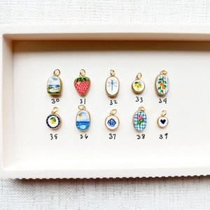 Vue détaillée de dix pendentifs en émail coloré aux motifs floraux et de fraises