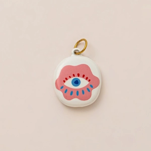 Detail of round evil eye enamel pendant with pink clouds and 18K gold plated loop