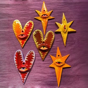 Detailed close-up of 18K gold-plated heart and star charms with colorful enamel evil eyes