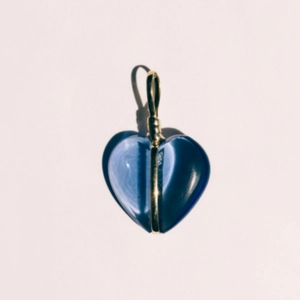 Macro detail van een hartvormige donkerblauwe zirkoon hanger met gepolijste gouden kern