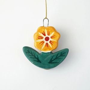 Détail macro du pendentif fleur plaqué or 18 carats avec pétales jaunes et centre rouge