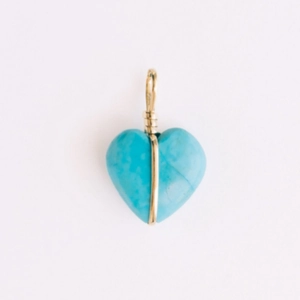 Detail van blauwe hart turquoise hanger met gouden draadwikkeling en textuur