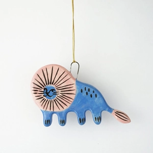 Détail d'un pendentif lion en céramique fait main avec motifs roses et bleus