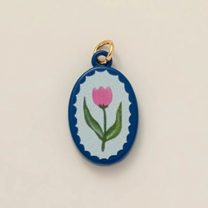 Detail of oval royal blue pendant with pink tulip pattern and gold mounting loop
