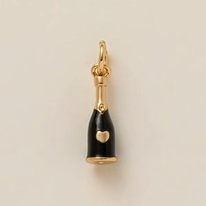 Detail view of a champagne bottle jewelry pendant with black enamel and a gold heart