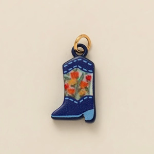 Detailopname van donkerblauwe emaille laars hanger met bloemenpatroon en gouden ring