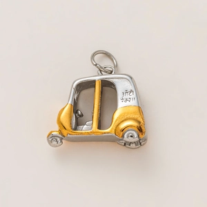 Detailed macro view of a two-tone rickshaw pendant in gold and silver stainless steel