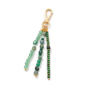 Detail of bohemian gold keychain with triple strands of green natural stone beads