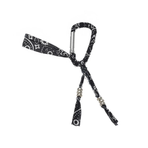 Detail of silver carabiner keychain wrapped in black and white paisley fabric trim