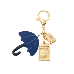 London themed gold keychain featuring a blue umbrella, red bus, and luggage tag charms