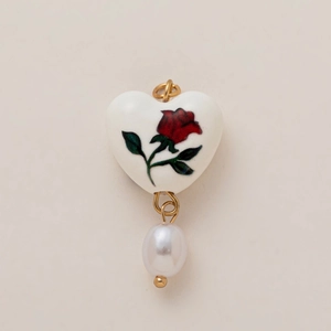 Dettaglio ciondolo a cuore in ceramica bianca con rosa rossa e perla a goccia