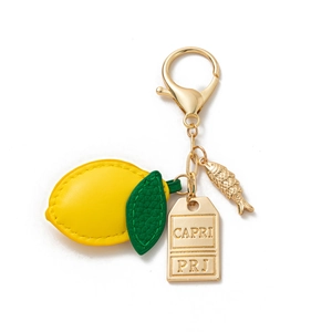 Detail of lemon leather keychain with Capri engraved tag and fish charm on gold chain