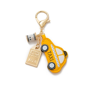 Detail of New York taxi leather charm with JFK metal tag and coffee cup keychain accessory