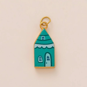Detailed macro of a gold-rimmed blue enamel house pendant with fairy tale charm design