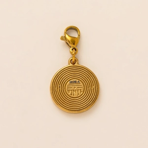 Dettaglio del ciondolo a disco placcato oro 18K con incisione Side A e Vinyl