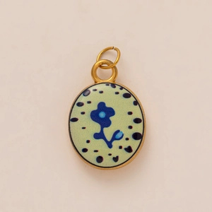 Pendentif ovale en acier titane avec cadre doré et motif floral vert clair
