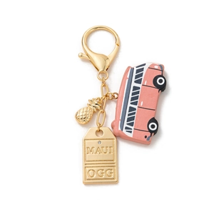 Close-up of golden keychain with Maui metal plate, pineapple, and coral camper bus charms