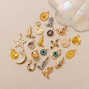 Collection of gold and silver celestial charms including stars, moon, and cross pendants