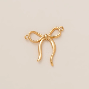 Detailed close-up of a 18K gold-plated bow-shaped metal pendant with dual connector rings