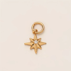 Detailed macro view of a gold-plated star pendant with a brilliant center zircon
