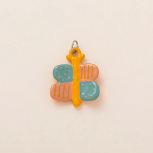 Close-up of a colorful butterfly charm with pastel enamel finish and silver metal ring
