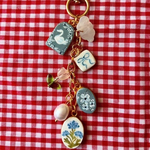 Porte-clés coloré avec breloques de cygne et tulipe sur tissu à carreaux rouge