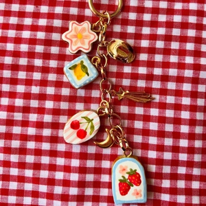 Porte-clés coloré avec pendentifs fleurs et fruits sur fond à carreaux rouge et blanc