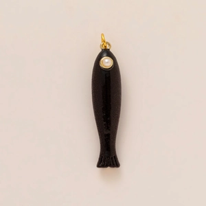 Makroansicht eines schwarzen Fisch-Anhängers mit Goldring und weißer Perle am Auge
