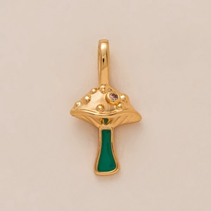 Detail of mushroom pendant with pink gemstone and green enamel in gold plating
