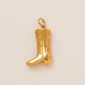 Primer plano detallado del colgante de bota de vaquero bañado en oro 18K con grabados