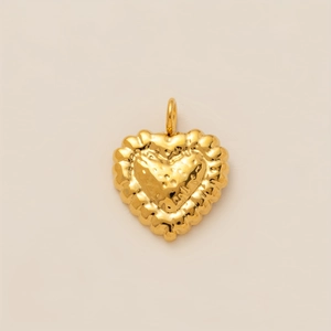 Dettaglio macro di un ciondolo a cuore placcato oro 18K con finitura martellata unica