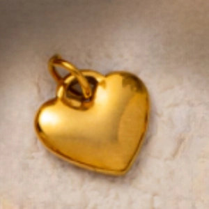 Vista macro di un ciondolo a forma di cuore placcato oro 18K con superficie lucida